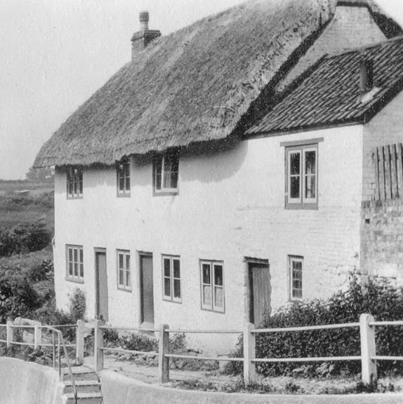 This property still stands, but is now one house and no longer thatched